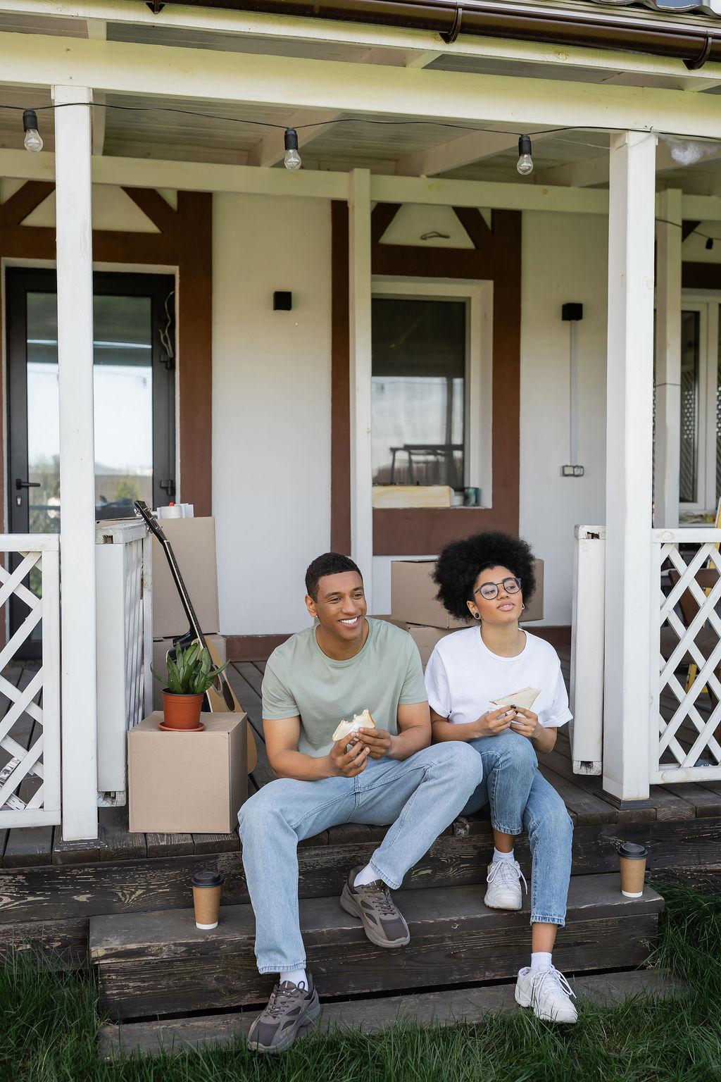 A young couple on the steps of their new home