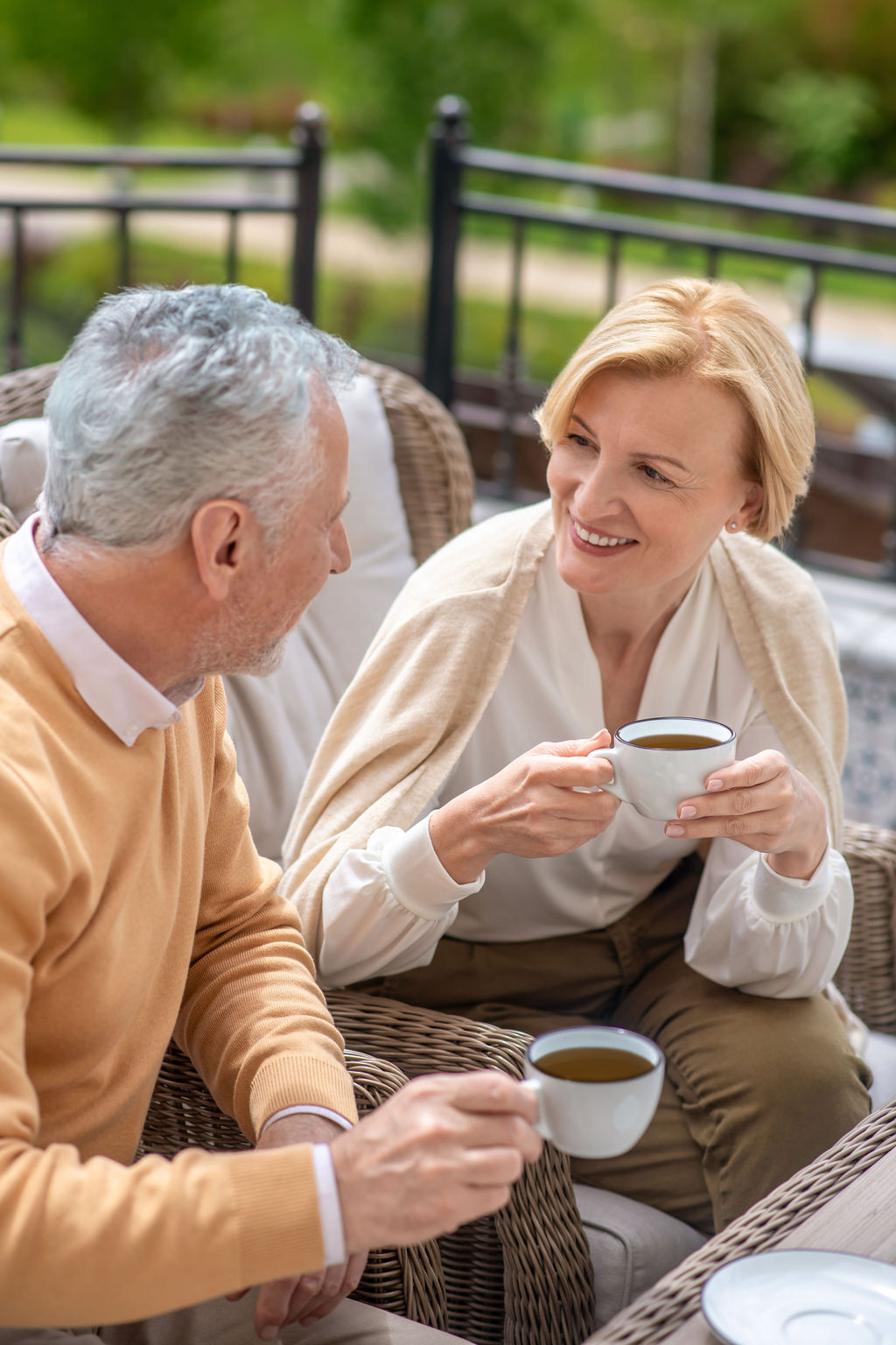 A couple talking over coffee on their patio