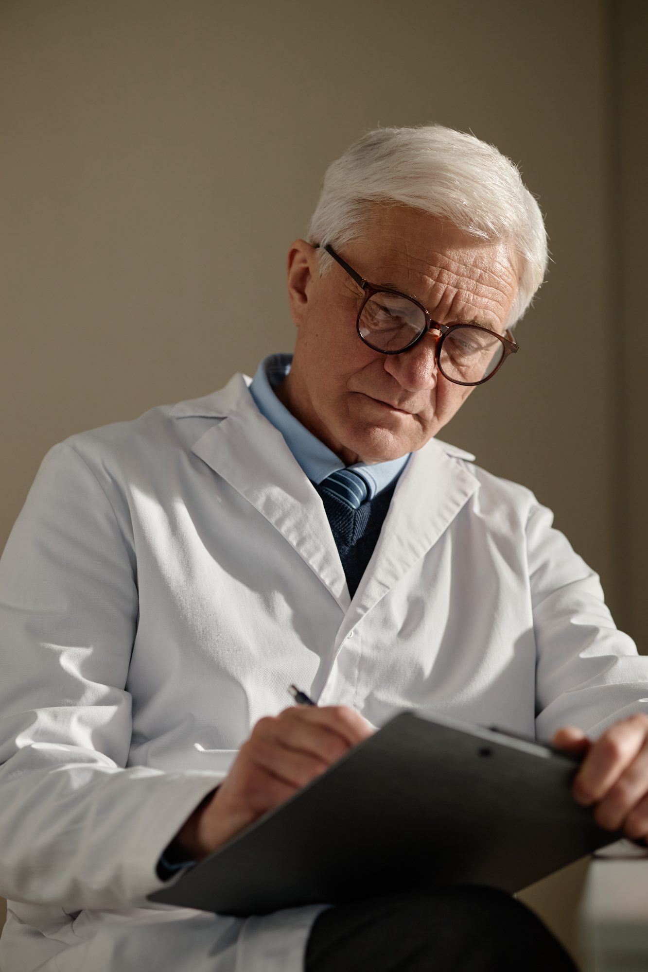 A physician making notes on a patient chart